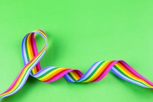 2. Colorful rainbow ribbon strip on green pastel background. Concept of cheering LGBT communities all over the world photo