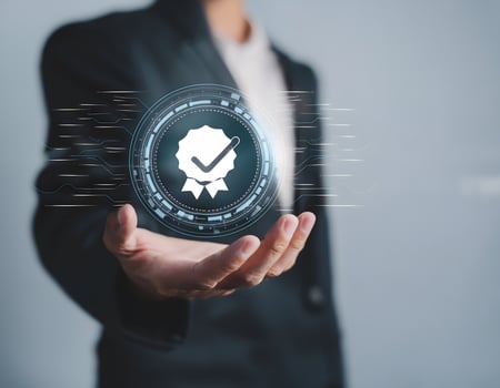 Businessman holding a golden quality assurance badge, symbolizing high standards and certification photo