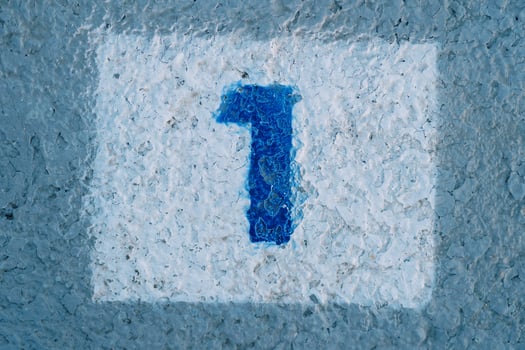 Blue number one is painted on the wall in a white rectangle photo