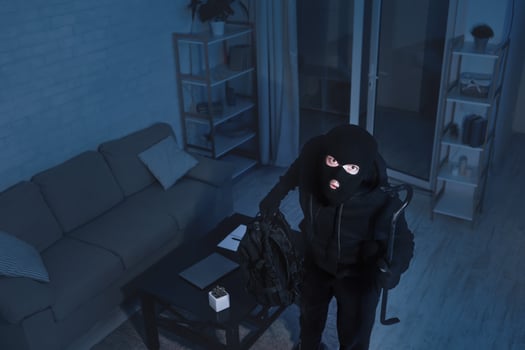 Robbery Concept. The surveillance camera captured as a masked thief breaks the apartment and looking up photo