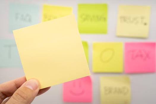 Hand holding Blank Sticky note with colorful sticky notes background. Copy space for text or infographic. photo