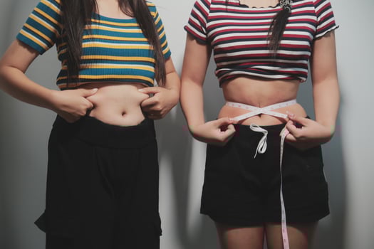 Two women standing next to each other with their stomachs photo