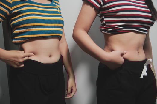 Two women standing next to each other with their stomachs photo