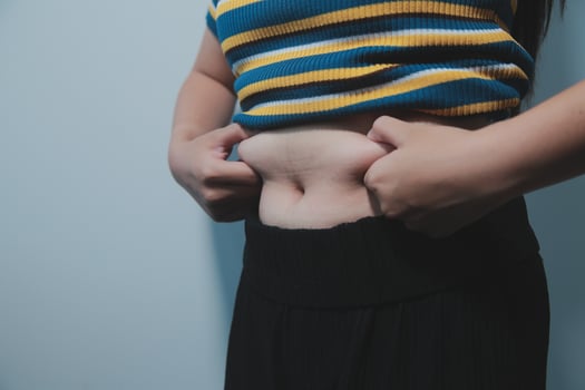 A woman with a belly showing off her stomach photo