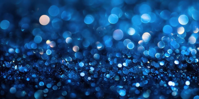 Shimmering blue bokeh effect created by light reflecting off tiny particles during a nighttime setting photo