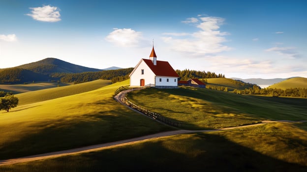 Small Church On A Hill With Scenic Countryside, Peaceful Landscape And Rolling Hills Under A Clear Sky photo