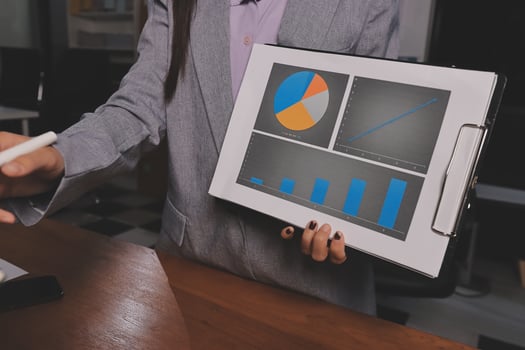 A businesswoman is holding a tablet with a graph on it photo