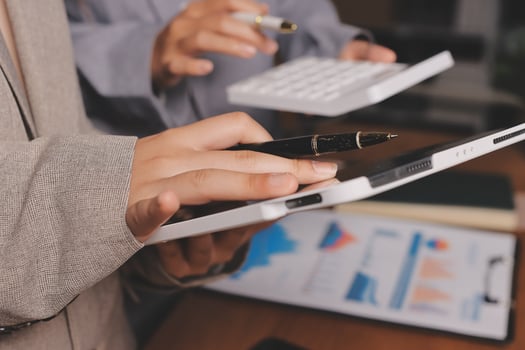 Business people using a tablet and pen to write on a paper photo