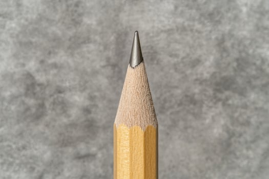 Close up of a sharpened pencil against a textured background photo