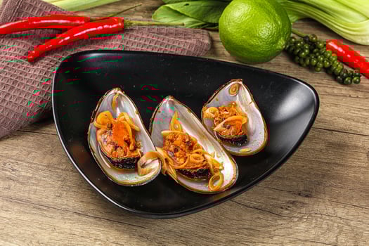 A black plate with three mussels on it photo