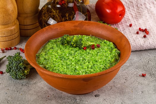 A bowl of broccoli and a bowl of tomato sauce photo