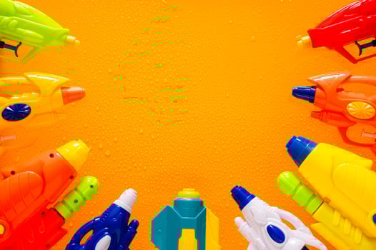 Water guns put on wet yellow background for Minimal Thailand Songkran festival celebration concept. photo
