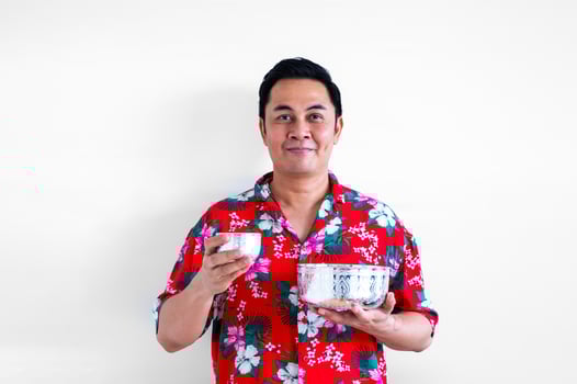 Thai male wears colorful shirt holding big and small water bowl for Thailand songkran festival concept. photo