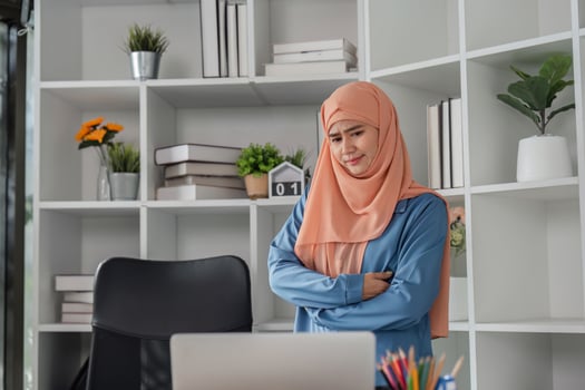 Diverse female accountant with a thoughtful expression reflecting on financial reports in an office. photo