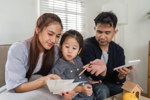 Family bonding over financial discussions, encouraging their child to understand savings and budgeting. photo