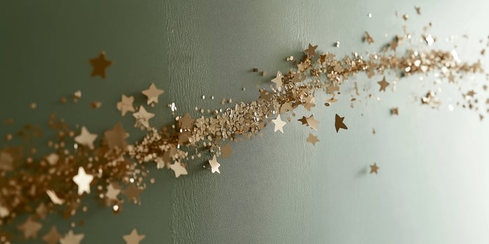 Elegant golden cutlery arranged with star confetti on a green backdrop for a festive occasion photo