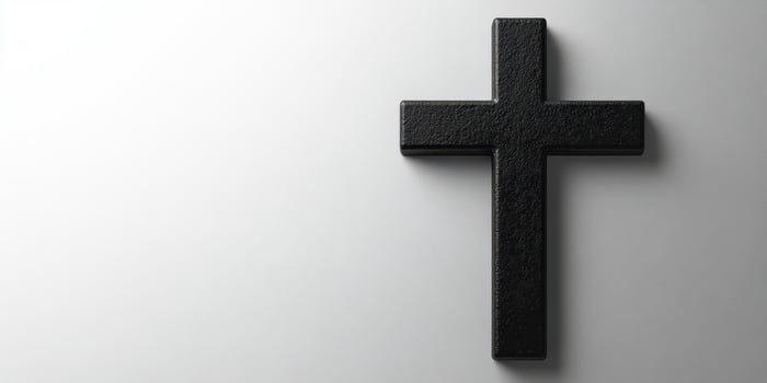 Black cross placed against a soft white background creating an impactful visual statement of faith photo