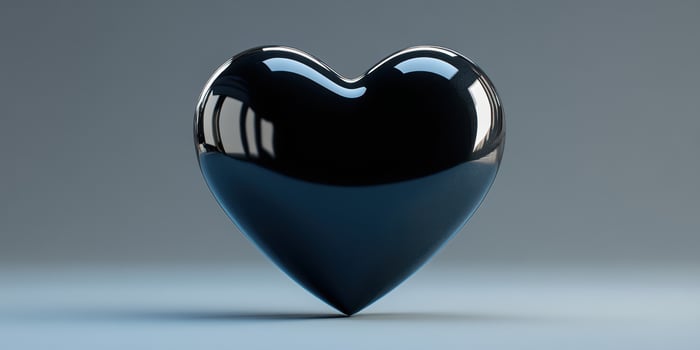 Glossy black heart shape on a minimalist blue background photo