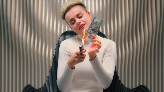 Caucasian female business woman rich wealthy girl crazy insane bizarre businesswoman laugh burn money cash fooling having fun rejoice hold burning dollar laughter trick joke cyberpunk futurism concept photo