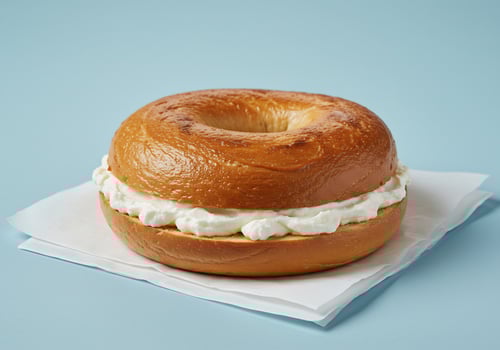 Toasted bagel with creamy cheese spread. photo