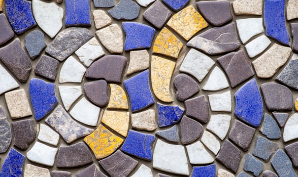 A colorful mosaic pattern featuring various stone pieces in swirls. photo