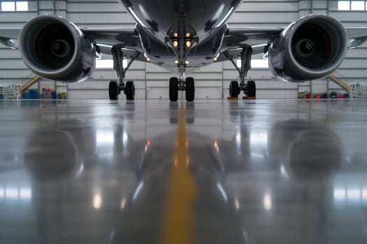 Jet underside reflection on polished hangar floor creates symmetrical abstract art photo