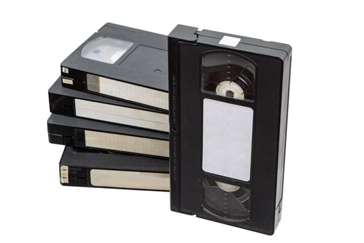 Stack of vintage VHS tapes, black plastic, blank labels, retro media, isolated on white background. photo