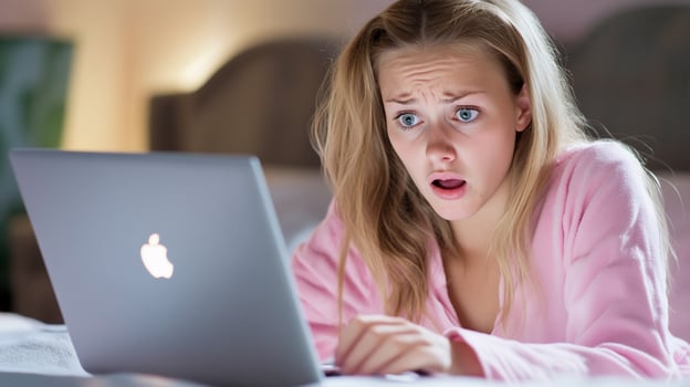 A surprised girl reacting to something on her laptop screen. photo