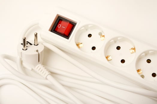 A white multi-plug extension cord with three receptacles on a snow-white surface. photo