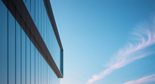 Modern building corner with expansive glass windows and a clear blue sky photo
