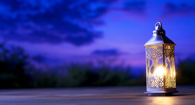 A decorative lantern emits a warm glow against a twilight backdrop. photo