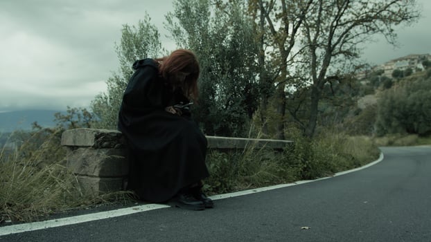 Christian Woman Prays With Crucifix Sitting Beside A Road In Nature photo