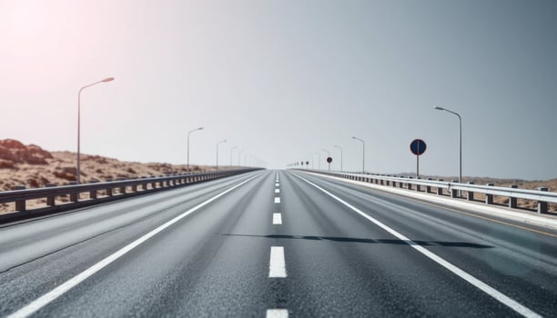Long Straight Highway Through Desert Landscape Under Bright Sun photo