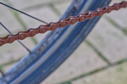 Rusty Bicycle Chain Close-Up next to tire photo