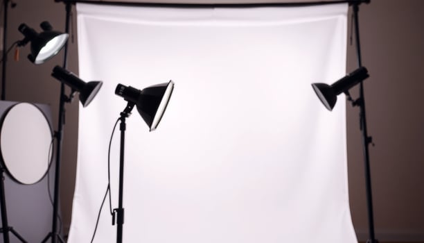 a photo studio with two lights and a white backdrop