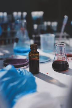 A person in a lab coat is holding a bottle of liquid photo