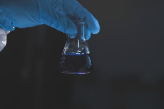 A person holding a test tube with blue liquid photo