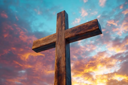 Large wooden christian cross standing against beautiful sunset sky photo
