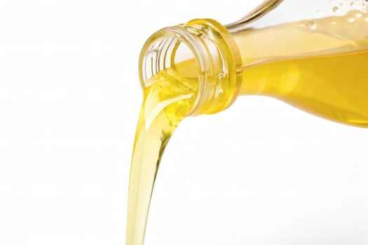Pouring golden liquid from a bottle, close-up. photo