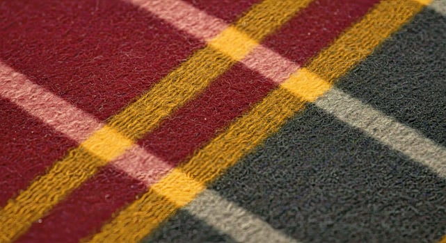 A close up of a red, yellow and black plaid rug photo