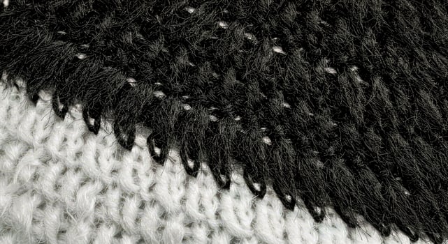 A close up of a black and white knitted scarf photo