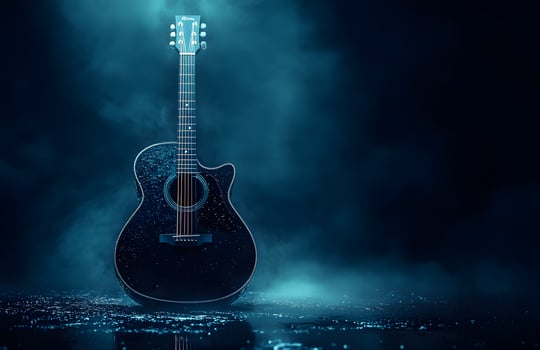 Black Acoustic Guitar In A Dark Moody Setting photo