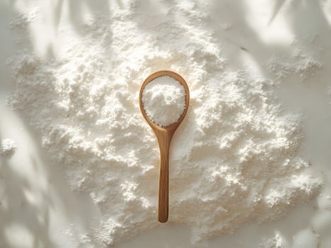Wooden Spoon of Flour on Pile of Flour photo