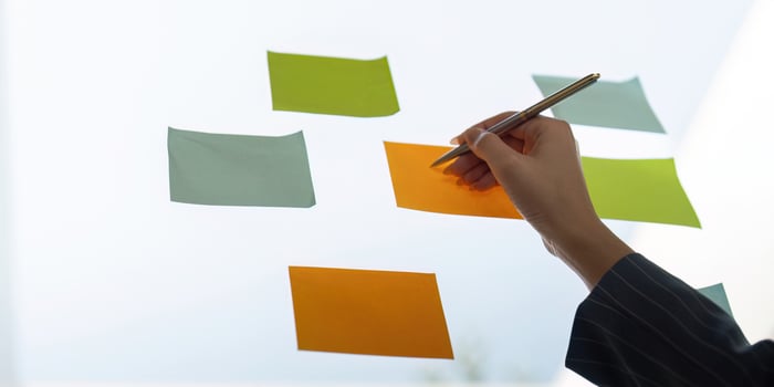 Colleagues sharing insights while arranging sticky notes for project planning and analysis. photo