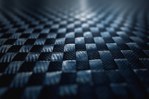 Close-up of a textured black woven surface, showcasing intricate patterns and light reflections. photo
