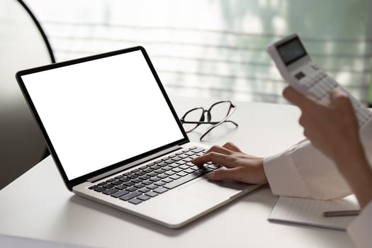 Close-up of a hand typing on a laptop while preparing financial documents for tax filing. photo