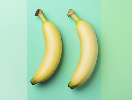 Fresh bananas in minimalistic arrangement on pastel green background, showcasing their vibrant yellow color and smooth texture photo