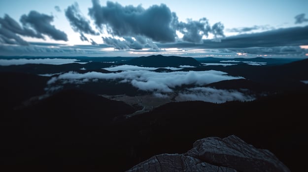 Vast mountain range enveloped in ethereal mist at dusk. photo