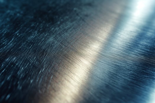 Close-up of brushed metal surface showcasing subtle reflections in cool tones. photo
