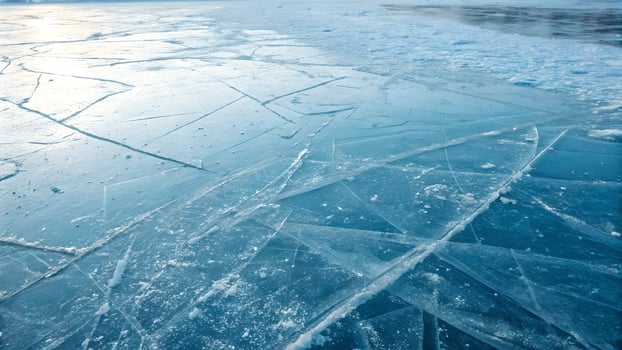 Frozen Lake Surface with Cracked Ice Patterns for Winter Backgrounds photo